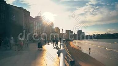 令人惊叹的<strong>金色光</strong>城堤日落与步行放松的人，城市建筑和海浪在美丽的l